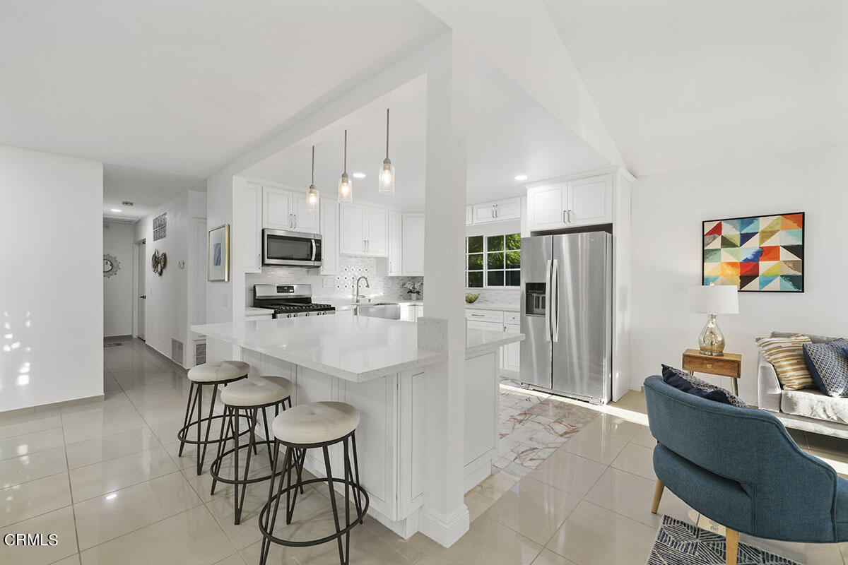 10842 Owens Place Tujunga, CA 91042 - Photo 16 of 68 a kitchen with stainless steel appliances kitchen island granite countertop a refrigerator and microwave