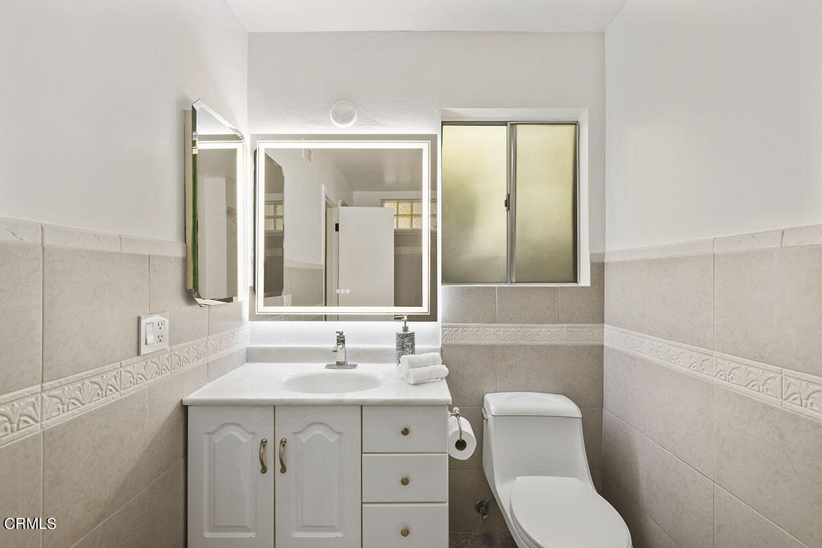 10842 Owens Place Tujunga, CA 91042 - Photo 36 of 68 a bathroom with a toilet a sink a mirror and vanity