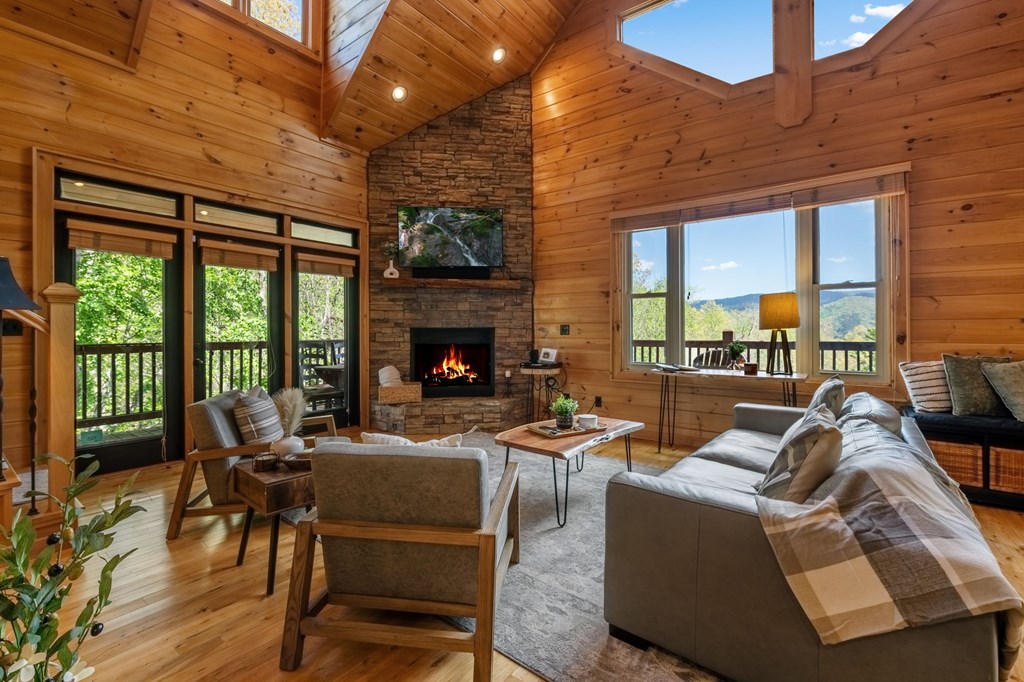 52 Whispering Lane Blue Ridge, GA 30513 - Photo 6 of 35 a living room with furniture a fireplace and floor to ceiling windows