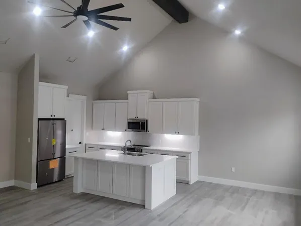 a kitchen with kitchen island white cabinets and stainless steel appliances