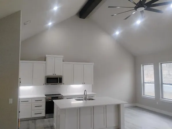 a kitchen with stainless steel appliances a sink a stove and microwave