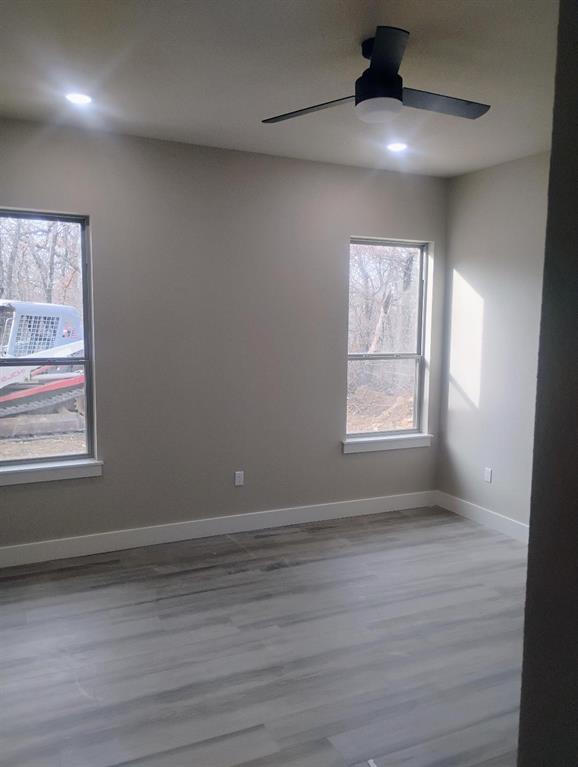 146 Hauser Place Runaway Bay, TX 76426 - Photo 9 of 15 an empty room with wooden floor chandelier fan and windows