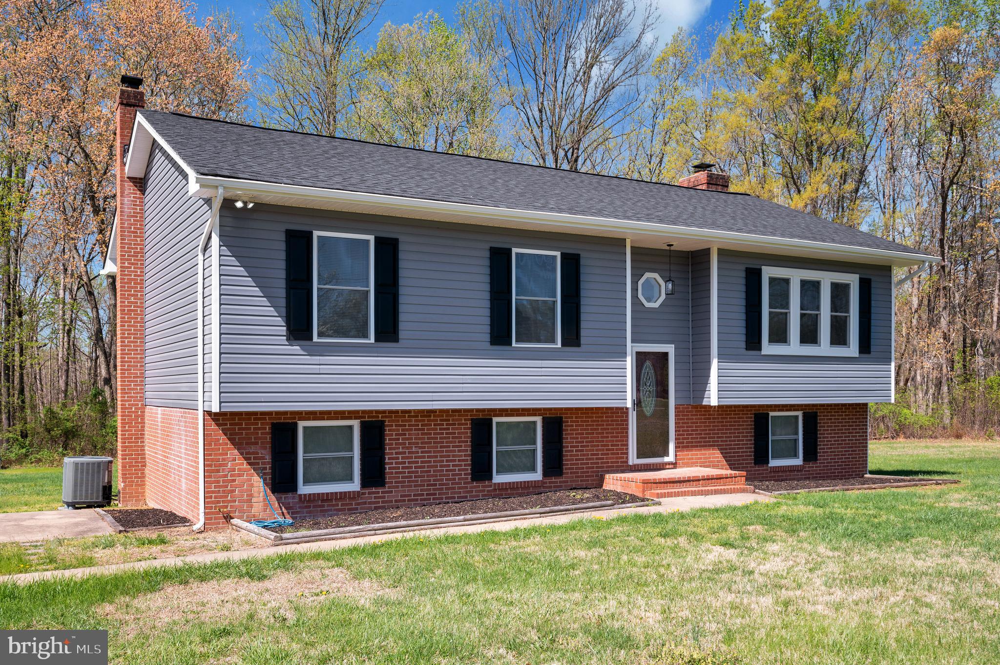 13452 Post Oak Road Spotsylvania, VA 22551 - Photo 8 of 56 a front view of a house with a yard and garage