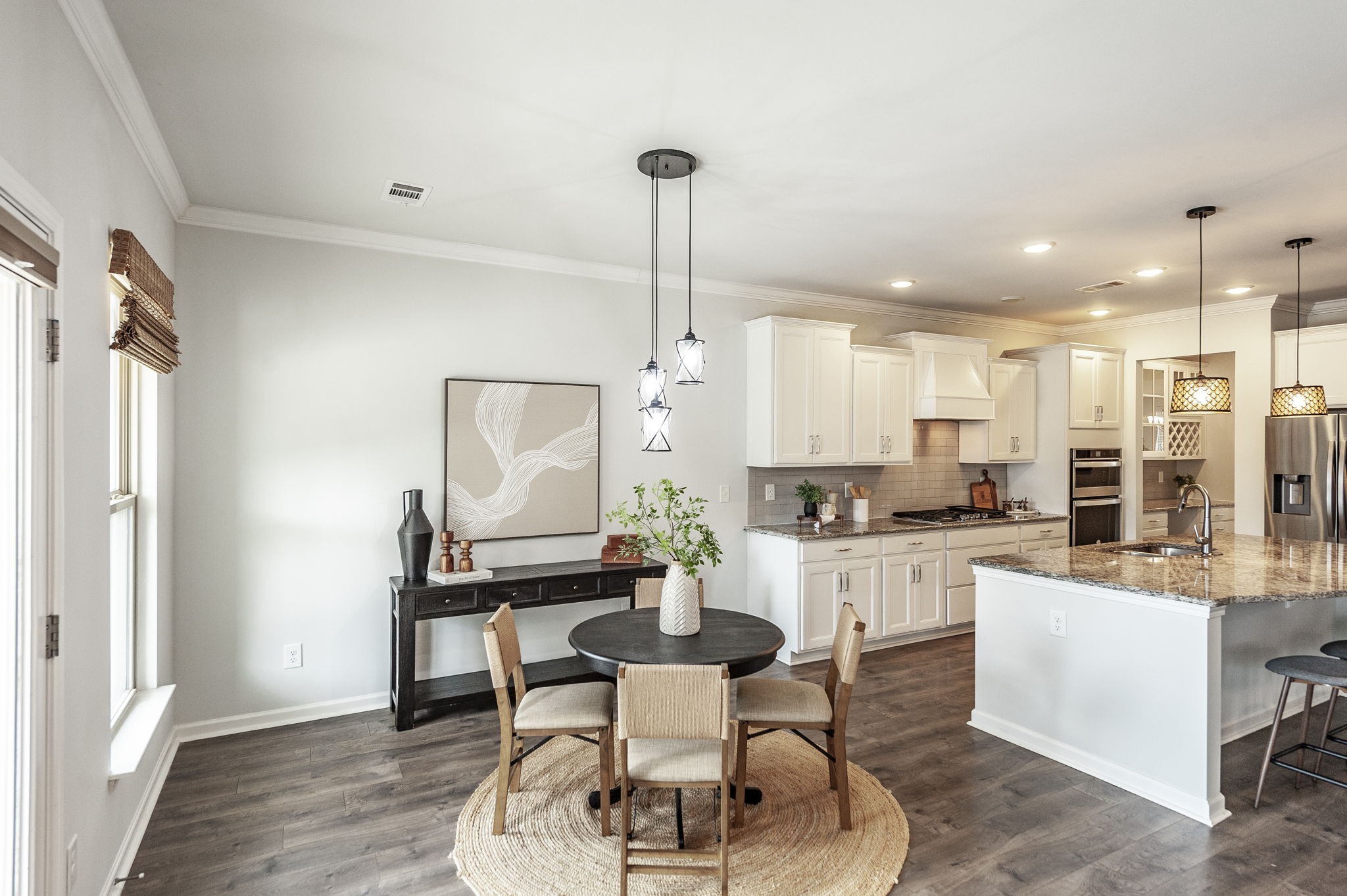 1095 Brixworth Drive Spring Hill, TN 37174 - Photo 12 of 49 a kitchen with kitchen island a dining table chairs stainless steel appliances and cabinets