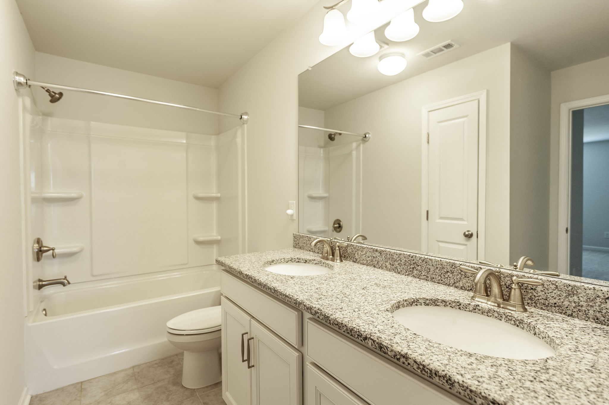 1095 Brixworth Drive Spring Hill, TN 37174 - Photo 35 of 49 a bathroom with a granite countertop double vanity sink mirror bathtub shower and toilet