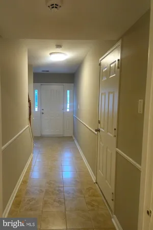 a view of a hallway with wooden floor and closet