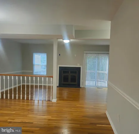 a view of a livingroom with wooden floor and a fireplace