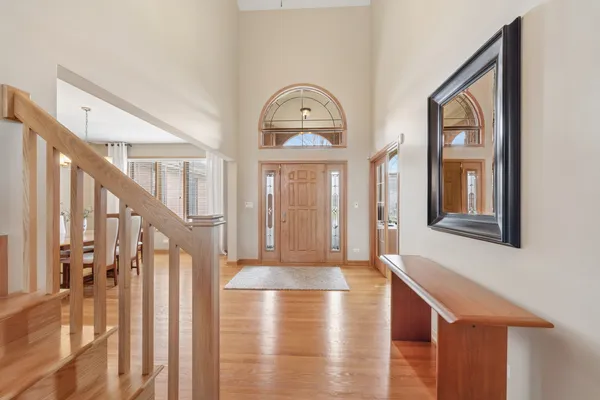 a view of a hallway with entryway wooden floor and front door