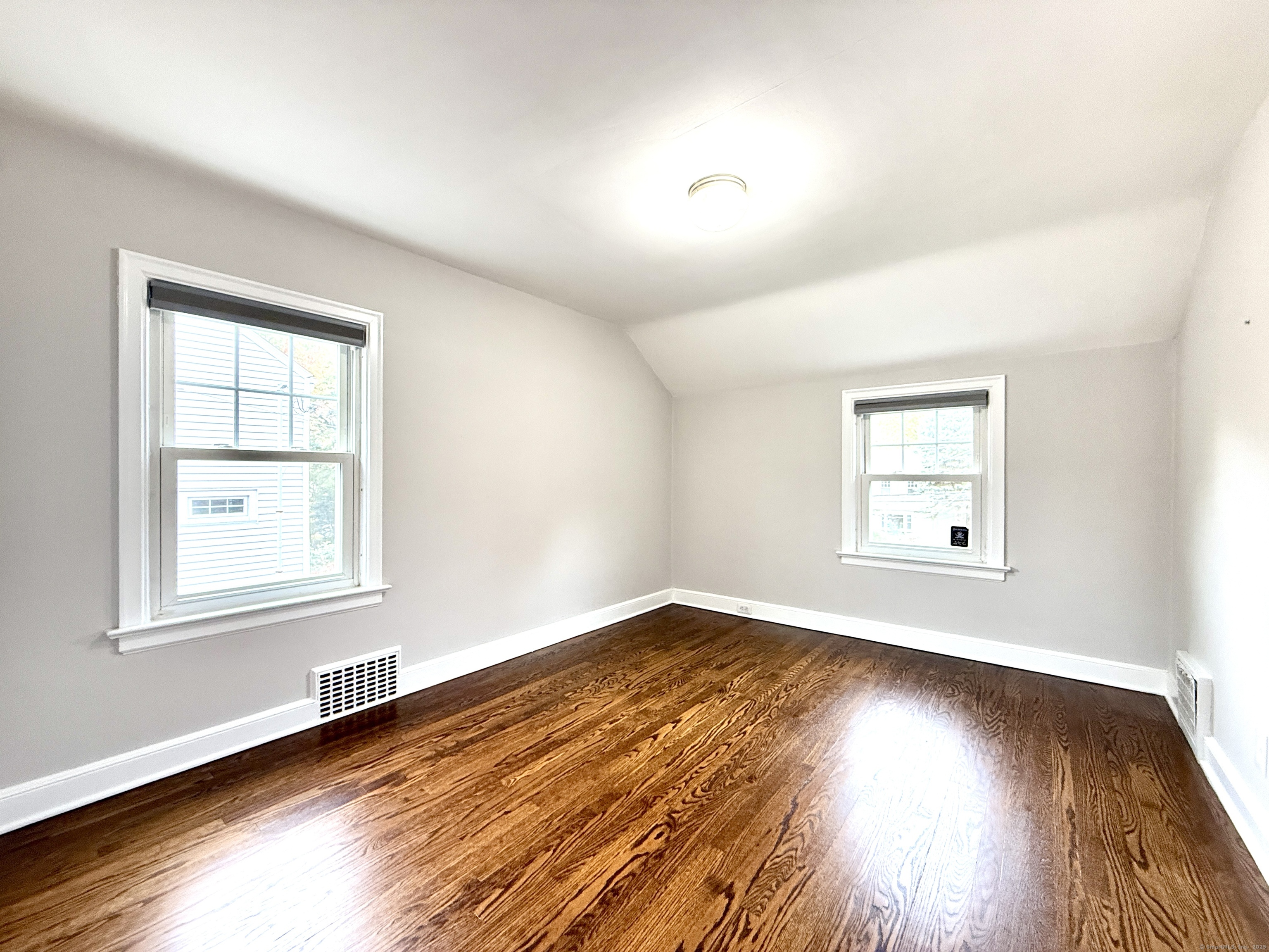 467 Wilson Street Fairfield, CT 06825 - Photo 15 of 18 an empty room with wooden floor and windows
