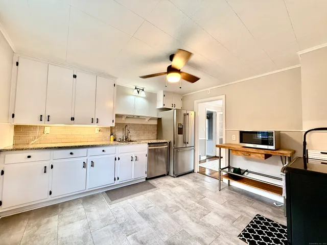 a kitchen with stainless steel appliances kitchen island granite countertop a refrigerator and a stove top oven