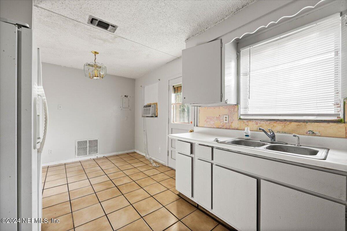 8988 Castle Boulevard Jacksonville, FL 32208 - Photo 11 of 28 a kitchen with a sink cabinets and window