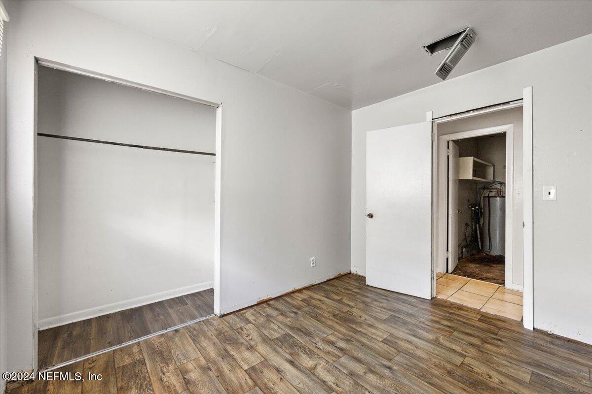 8988 Castle Boulevard Jacksonville, FL 32208 - Photo 13 of 28 a view of an empty room with wooden floor and a bathroom