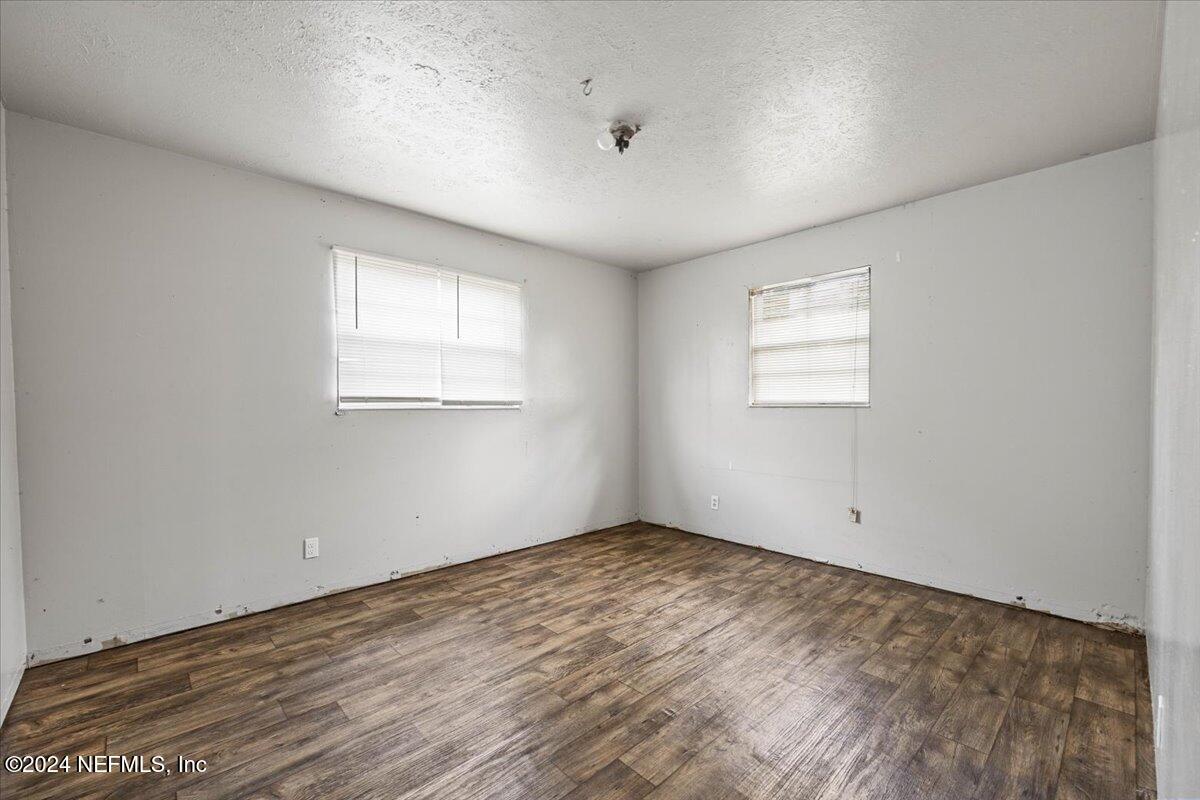 8988 Castle Boulevard Jacksonville, FL 32208 - Photo 15 of 28 an empty room with wooden floor and windows