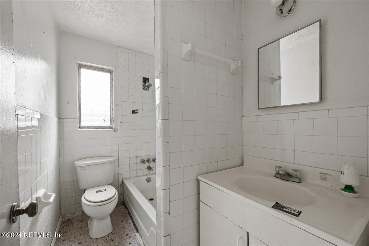 8988 Castle Boulevard Jacksonville, FL 32208 - Photo 18 of 28 a bathroom with a toilet sink and mirror