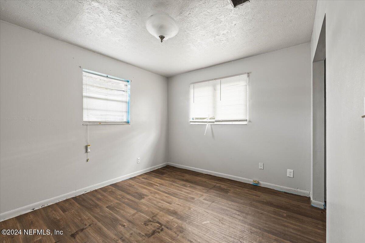 8988 Castle Boulevard Jacksonville, FL 32208 - Photo 19 of 28 an empty room with wooden floor and windows
