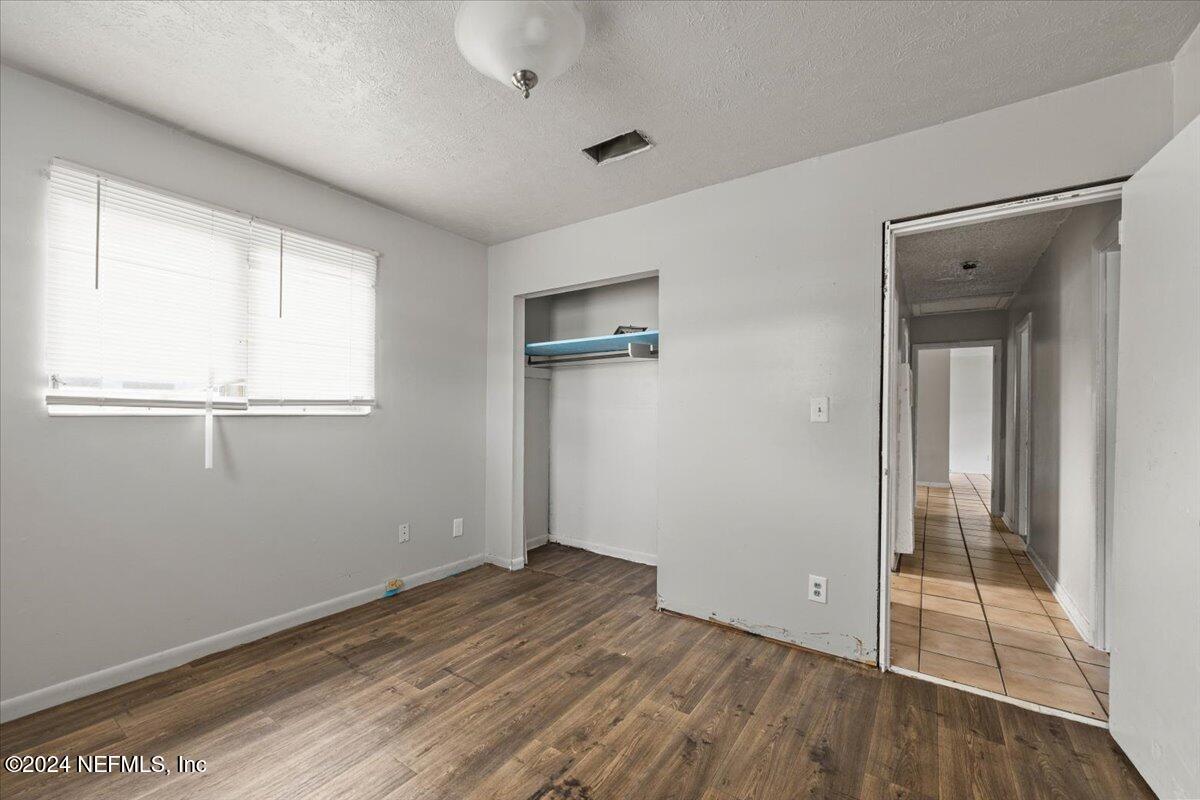 8988 Castle Boulevard Jacksonville, FL 32208 - Photo 20 of 28 an empty room with wooden floor and windows