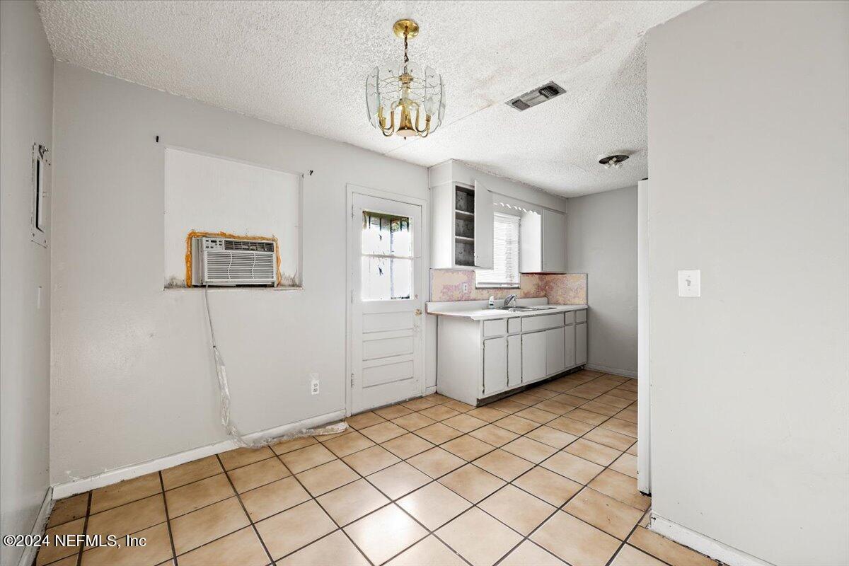 8988 Castle Boulevard Jacksonville, FL 32208 - Photo 9 of 28 a kitchen with a sink a counter top space and cabinets