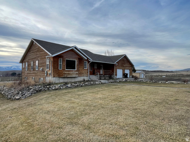 333 Lago Liberty Road Grace, ID 83241 - Photo 2 of 35 View of front facade featuring covered porch, a mountain view, a front yard, a garage, and roof with shingles