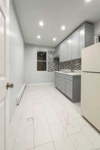 a view of kitchen with stainless steel appliances granite countertop a stove a refrigerator and a refrigerator with white cabinets