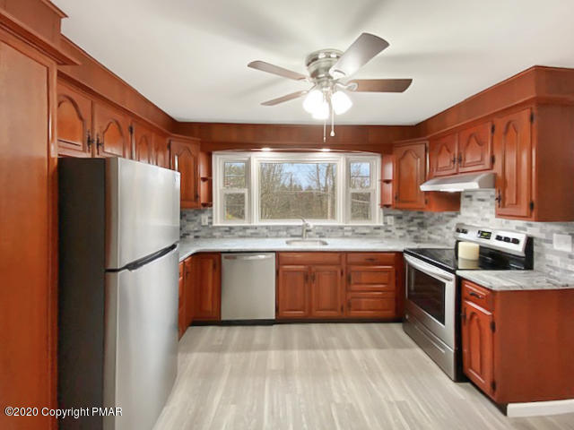 7522 Old Coach Road Stroudsburg, PA 18360 - Photo 17 of 68 a kitchen with granite countertop stainless steel appliances a refrigerator cabinets and wooden floor