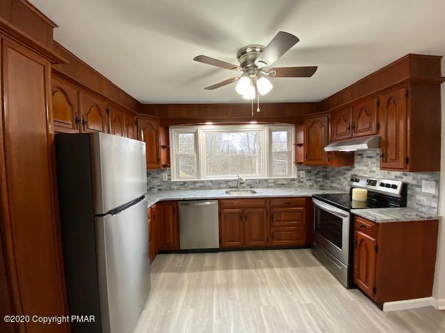 7522 Old Coach Road Stroudsburg, PA 18360 - Photo 20 of 68 a kitchen with stainless steel appliances granite countertop a refrigerator a sink dishwasher a stove with wooden cabinets and floor