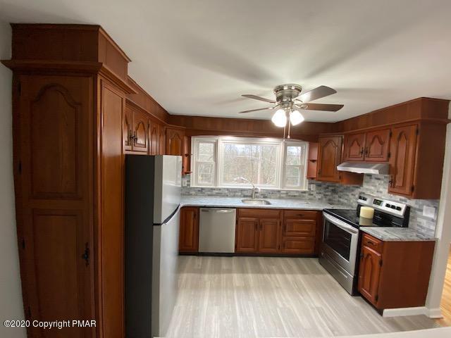 7522 Old Coach Road Stroudsburg, PA 18360 - Photo 24 of 68 a kitchen with stainless steel appliances granite countertop a refrigerator a sink dishwasher a stove and a dining table with wooden floor