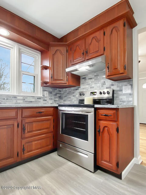 7522 Old Coach Road Stroudsburg, PA 18360 - Photo 27 of 68 a kitchen with granite countertop a sink cabinets stainless steel appliances and a counter space