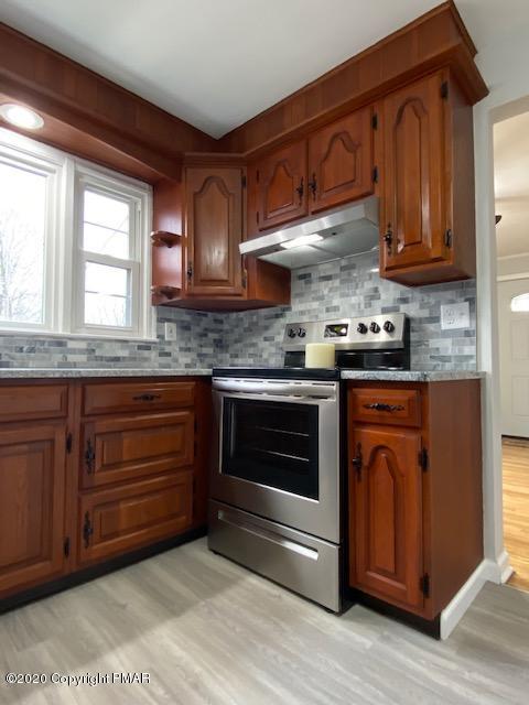 7522 Old Coach Road Stroudsburg, PA 18360 - Photo 28 of 68 a kitchen with granite countertop wooden cabinets stainless steel appliances and a window