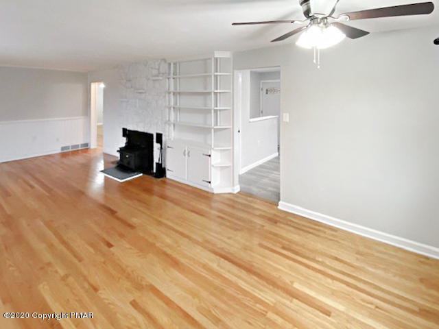 7522 Old Coach Road Stroudsburg, PA 18360 - Photo 33 of 68 a view of an empty room with a fireplace and a chandelier fan