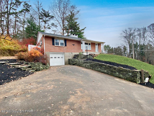 7522 Old Coach Road Stroudsburg, PA 18360 - Photo 5 of 68 a front view of a house with a yard and garage