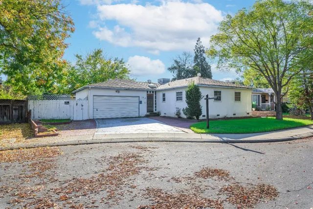 a view of a house with a yard and large tree