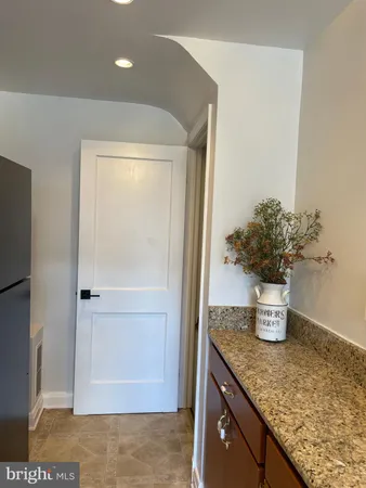 a kitchen with a granite countertop shower a sink and potted plant