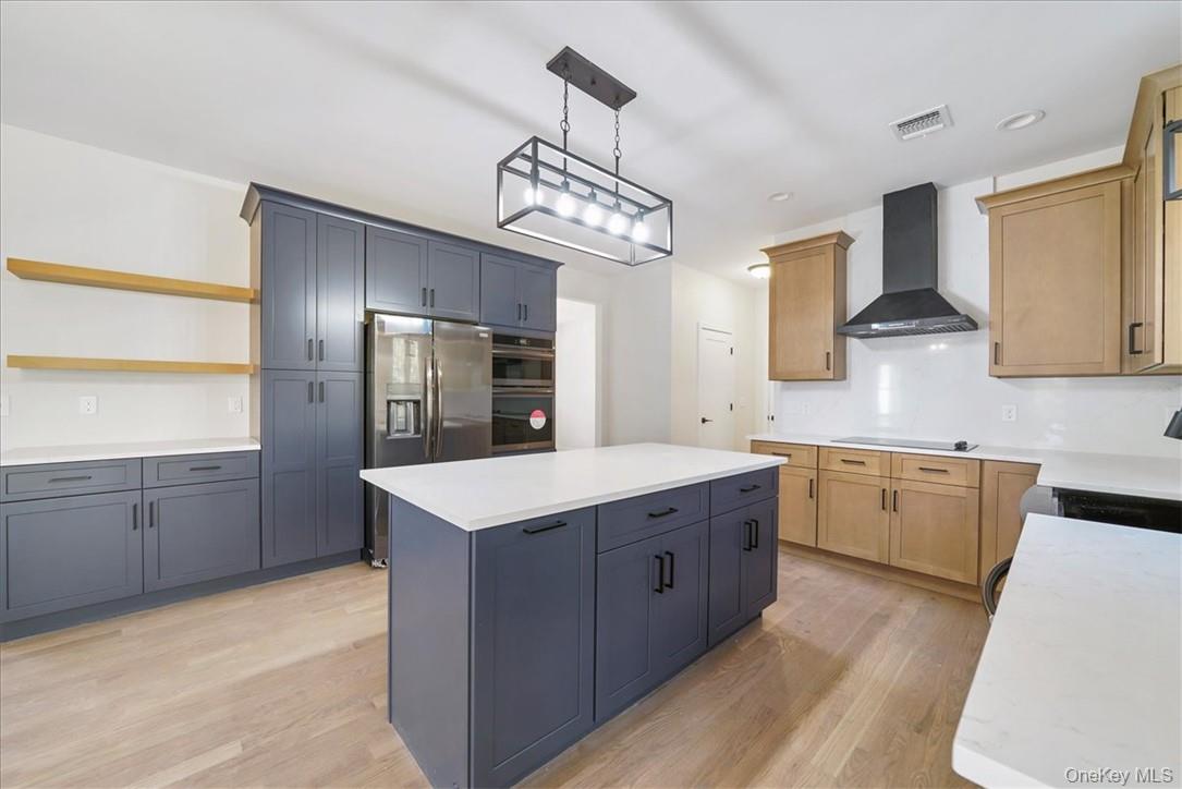 Lot 3-62 Camp Monroe Road Monroe, NY 10950 - Photo 12 of 39 Kitchen featuring wall chimney exhaust hood, light wood-type flooring, pendant lighting, a kitchen island, and black appliances