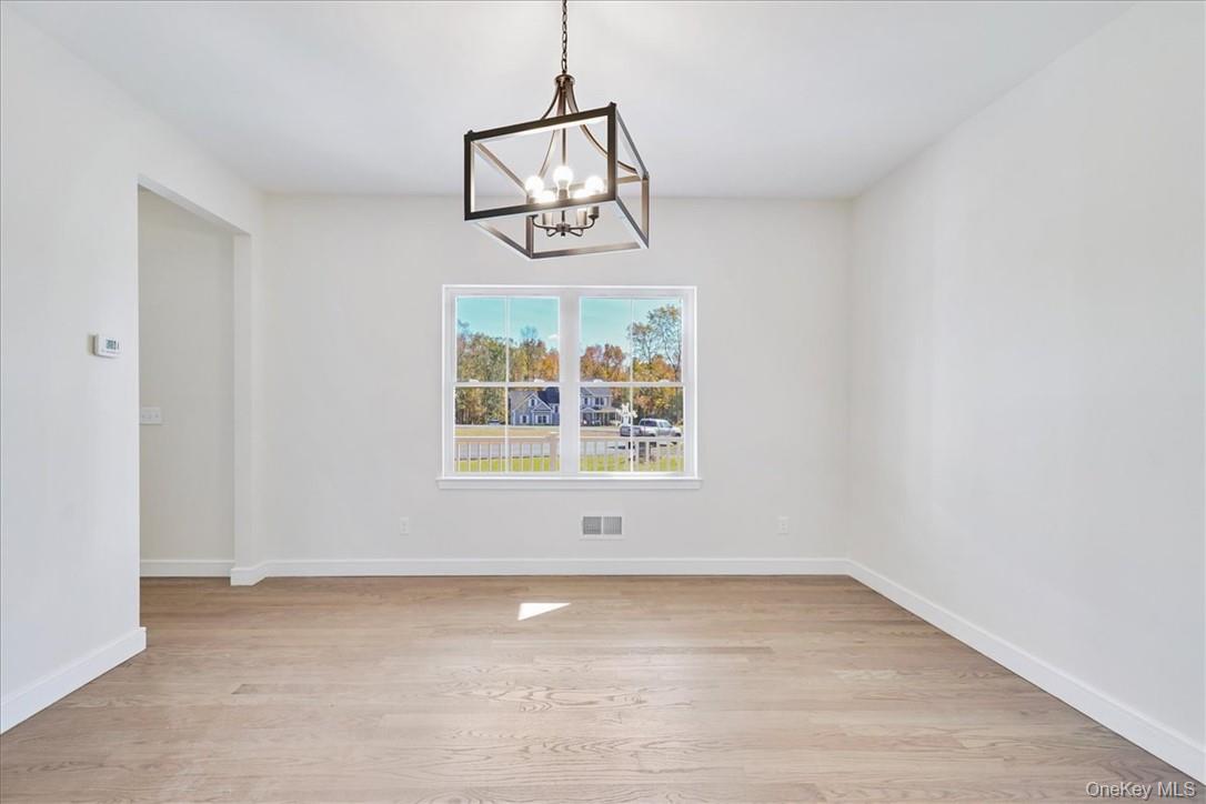 Lot 3-62 Camp Monroe Road Monroe, NY 10950 - Photo 17 of 39 Unfurnished dining area with light wood-type flooring and an inviting chandelier