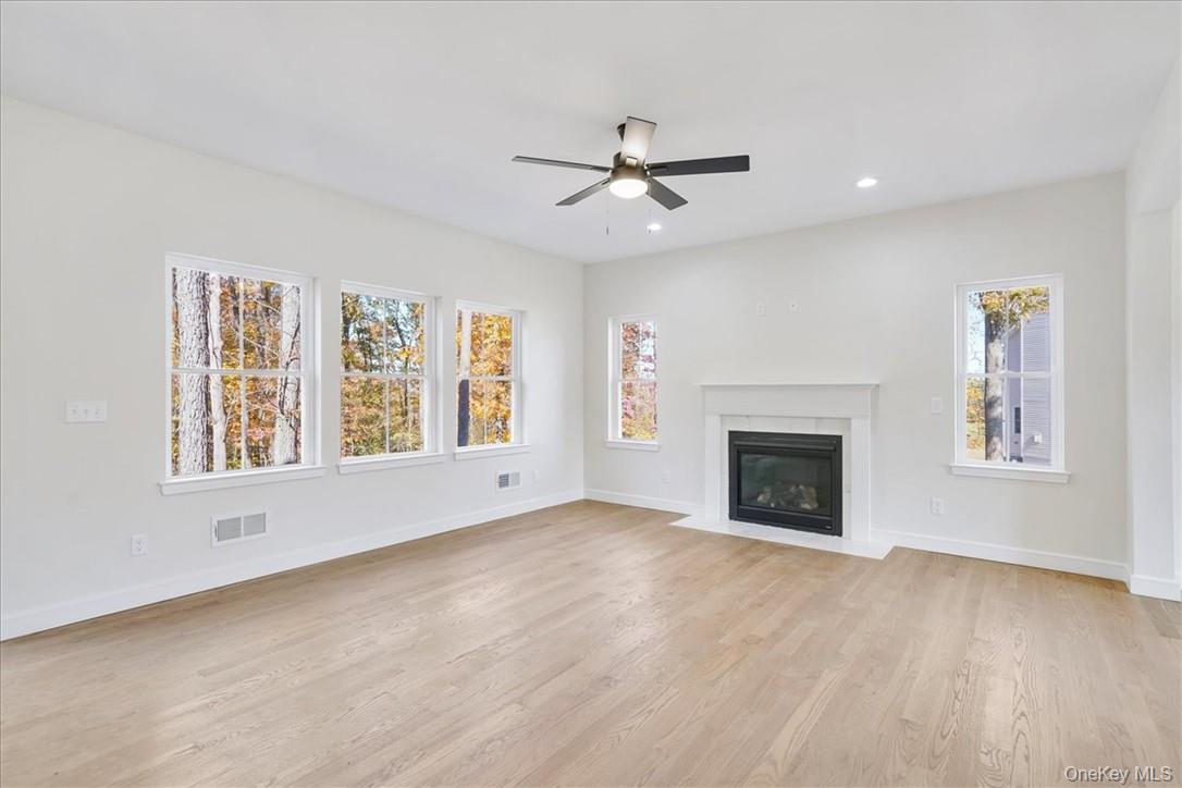 Lot 3-62 Camp Monroe Road Monroe, NY 10950 - Photo 8 of 39 Unfurnished living room featuring a healthy amount of sunlight, ceiling fan, and light hardwood / wood-style flooring
