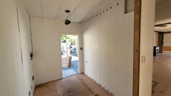 a view of a hallway view with wooden floor and a bathroom