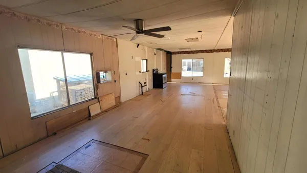 a view of a hallway with wooden floor and windows