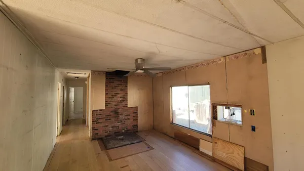 a hallway with wooden floor and windows