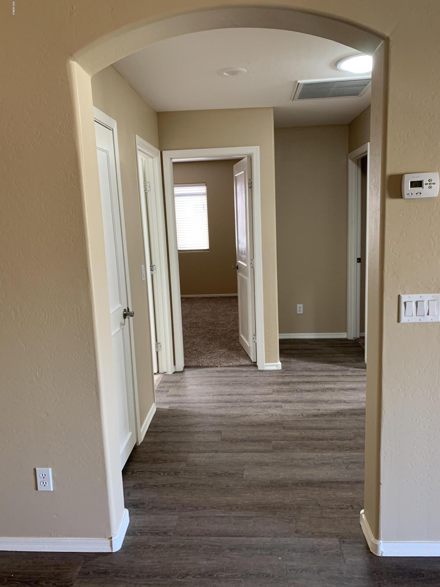2306 West Maldonado Road Phoenix, AZ 85041 - Photo 12 of 14 a view of a hallway with wooden floor
