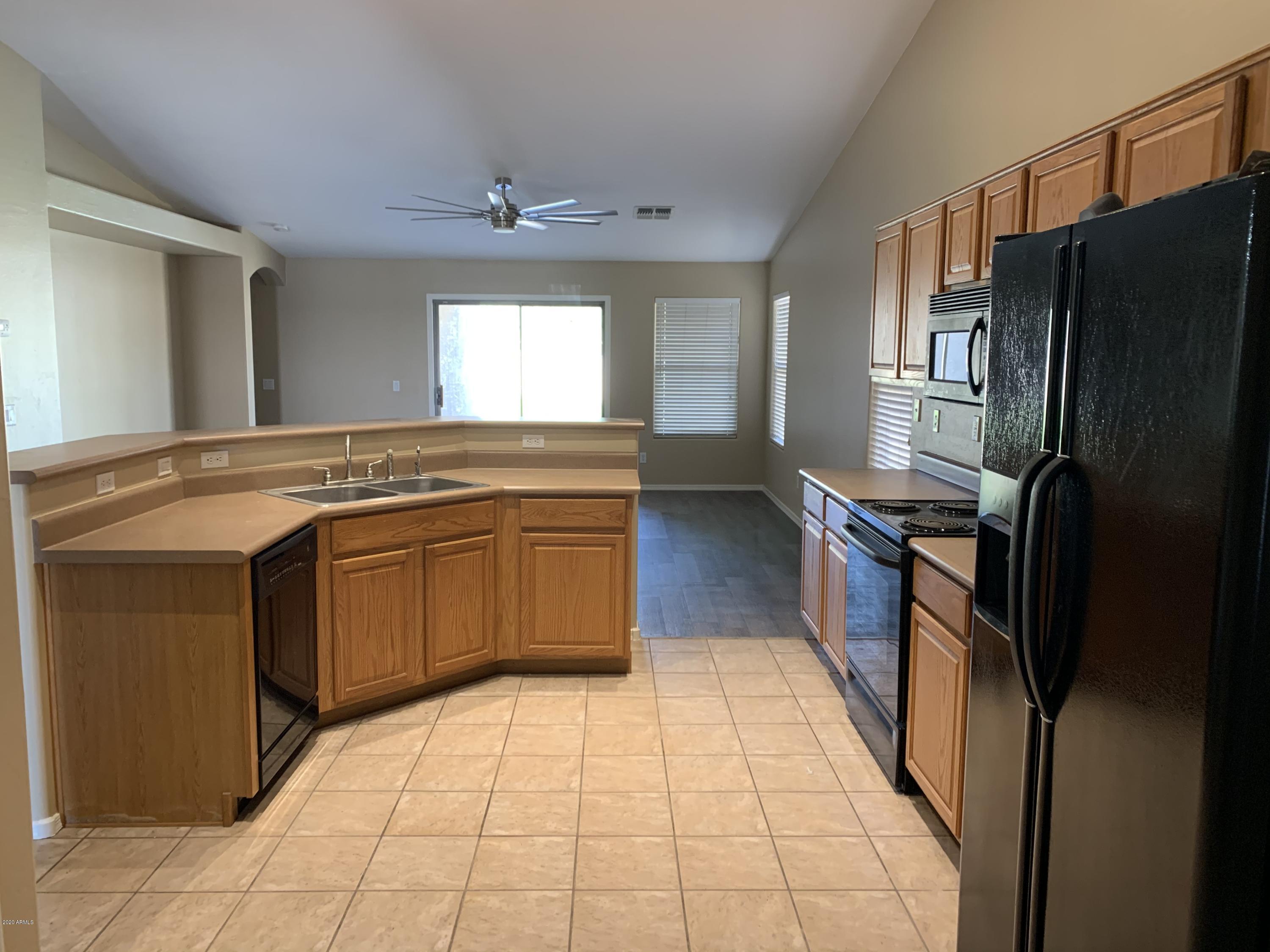 2306 West Maldonado Road Phoenix, AZ 85041 - Photo 3 of 14 a kitchen with stainless steel appliances granite countertop a sink stove and refrigerator