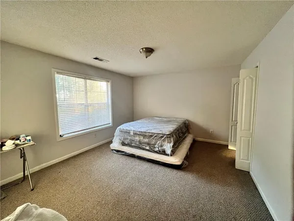 a spacious bedroom with a bed and a window