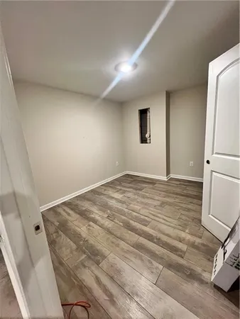 a view of a room with a refrigerator and wooden floor
