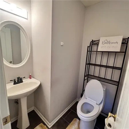 a bathroom with a toilet sink and mirror