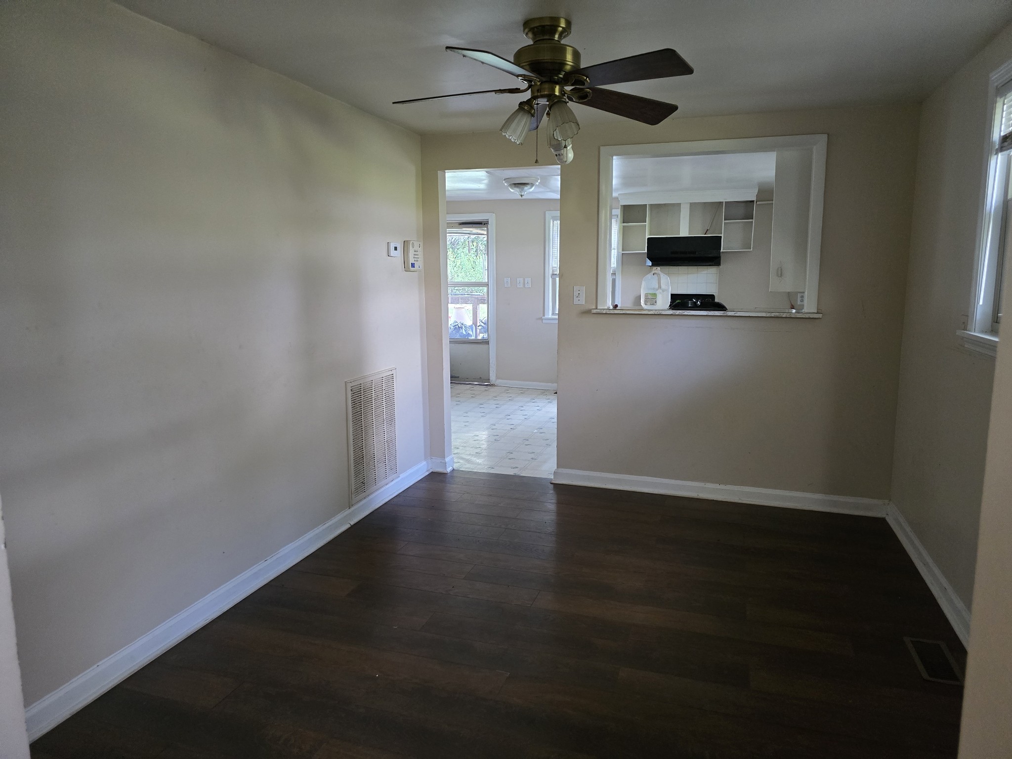 2606 Cave Springs Road Springfield, TN 37172 - Photo 14 of 27 an empty room with wooden floor a ceiling fan and a kitchen view