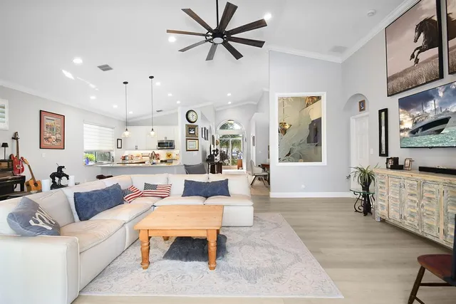 a living room with furniture a large window and a chandelier