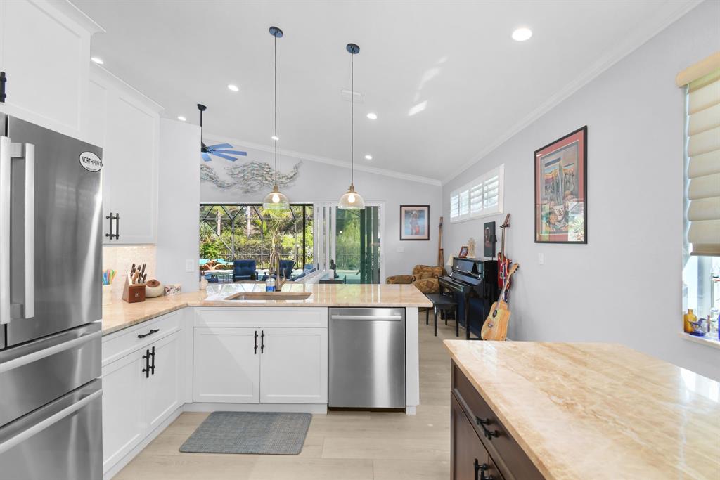 6848 Southeast Twin Oaks Circle Stuart, FL 34997 - Photo 17 of 70 a kitchen with a sink a stove a refrigerator and white cabinets