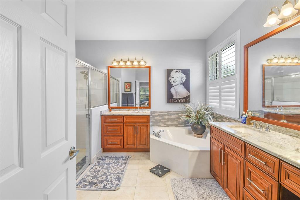 6848 Southeast Twin Oaks Circle Stuart, FL 34997 - Photo 25 of 70 a spacious bathroom with a granite countertop tub sink and mirror