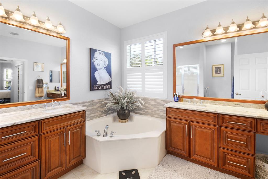 6848 Southeast Twin Oaks Circle Stuart, FL 34997 - Photo 27 of 70 a spacious bathroom with a granite countertop sink and a mirror