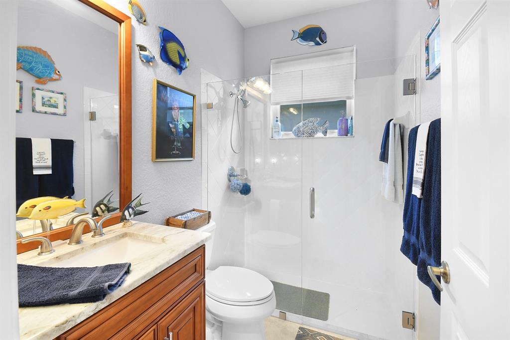 6848 Southeast Twin Oaks Circle Stuart, FL 34997 - Photo 29 of 70 a bathroom with a granite countertop sink toilet and shower