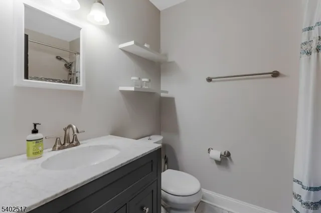 a bathroom with a granite countertop sink toilet and a mirror
